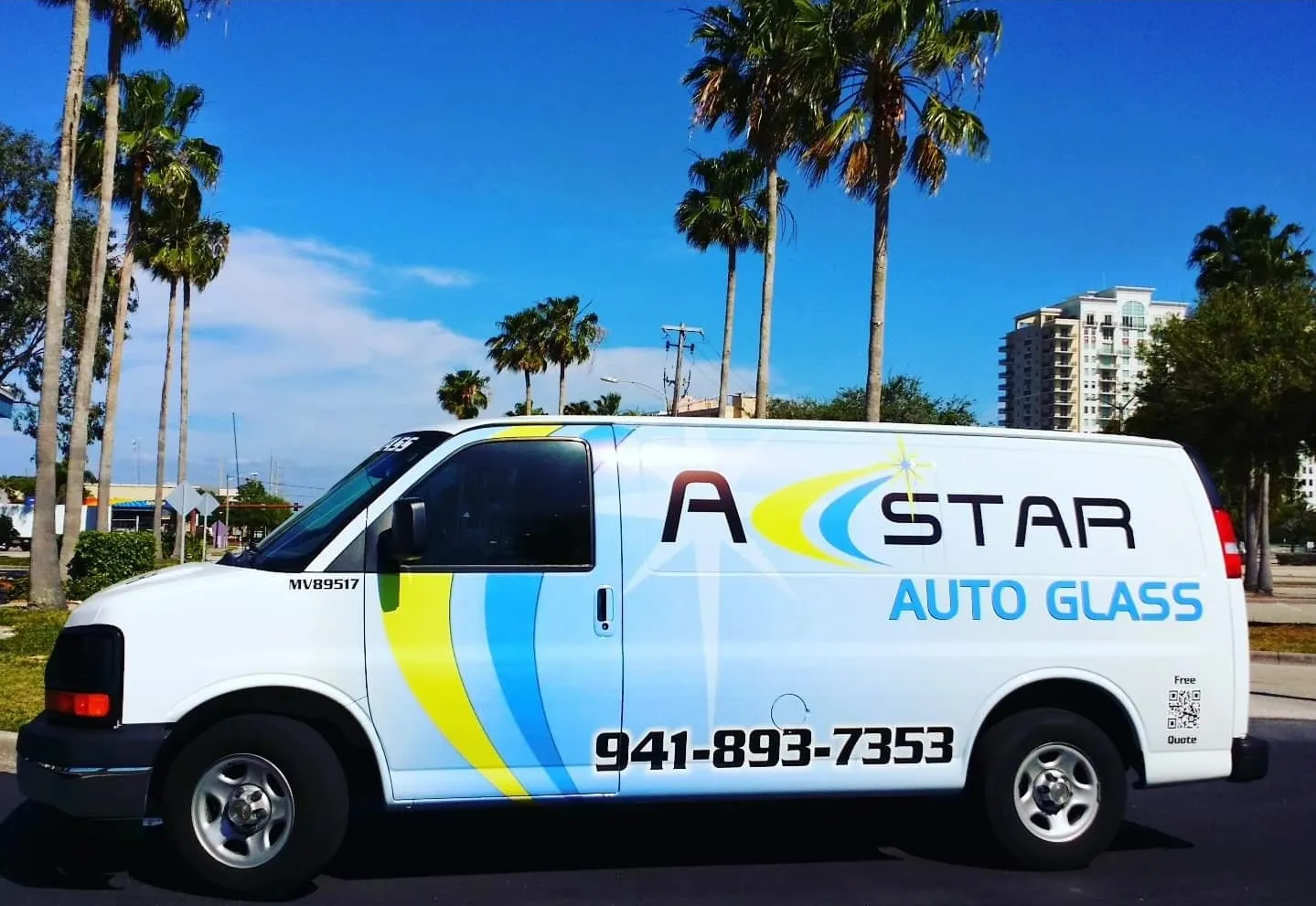 A Star Auto Glass mobile service van parked in Sarasota FL with palm trees and city skyline