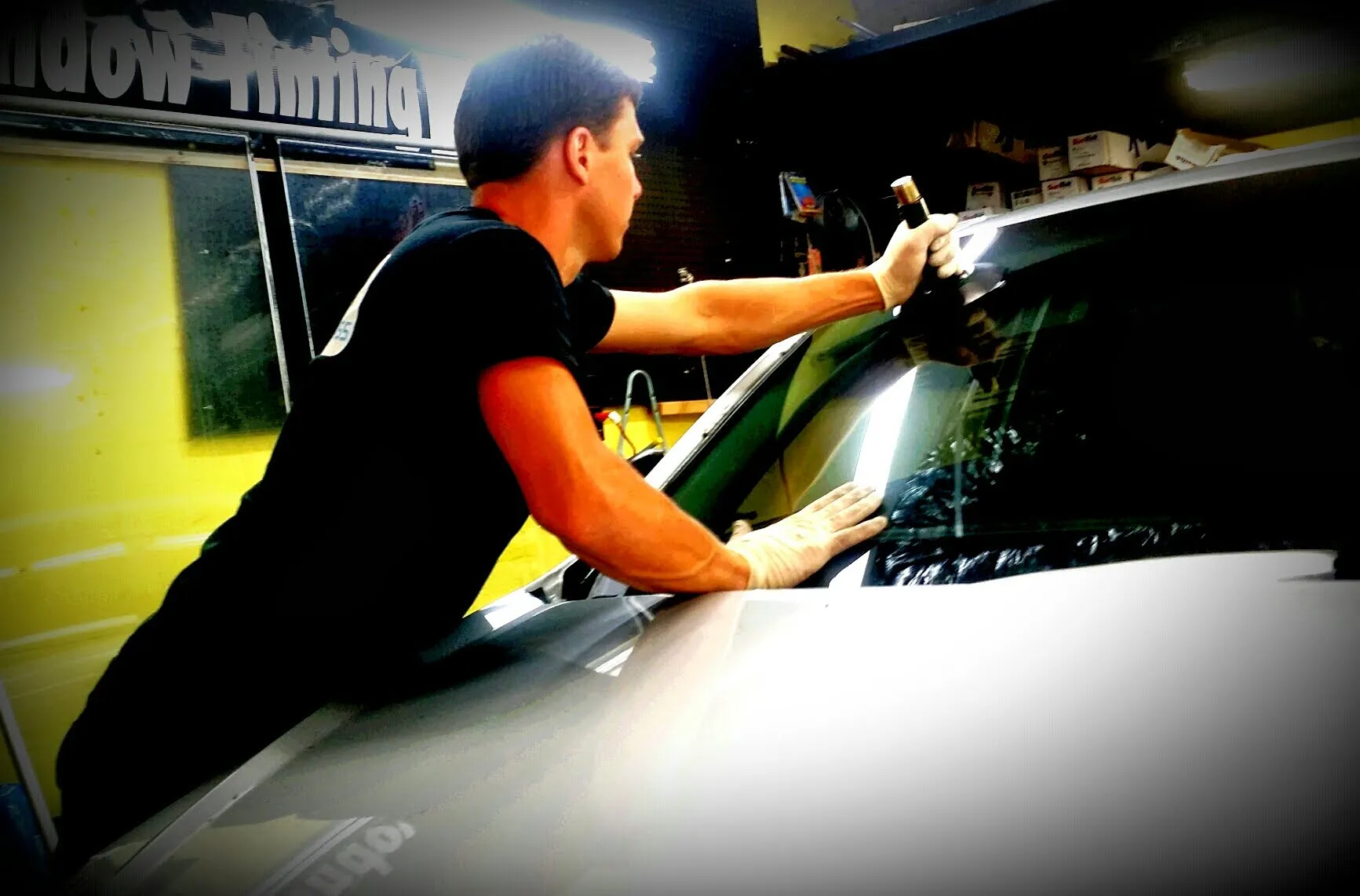 Alex Semencha founder of A Star Auto Glass working on a vehicle in the shop