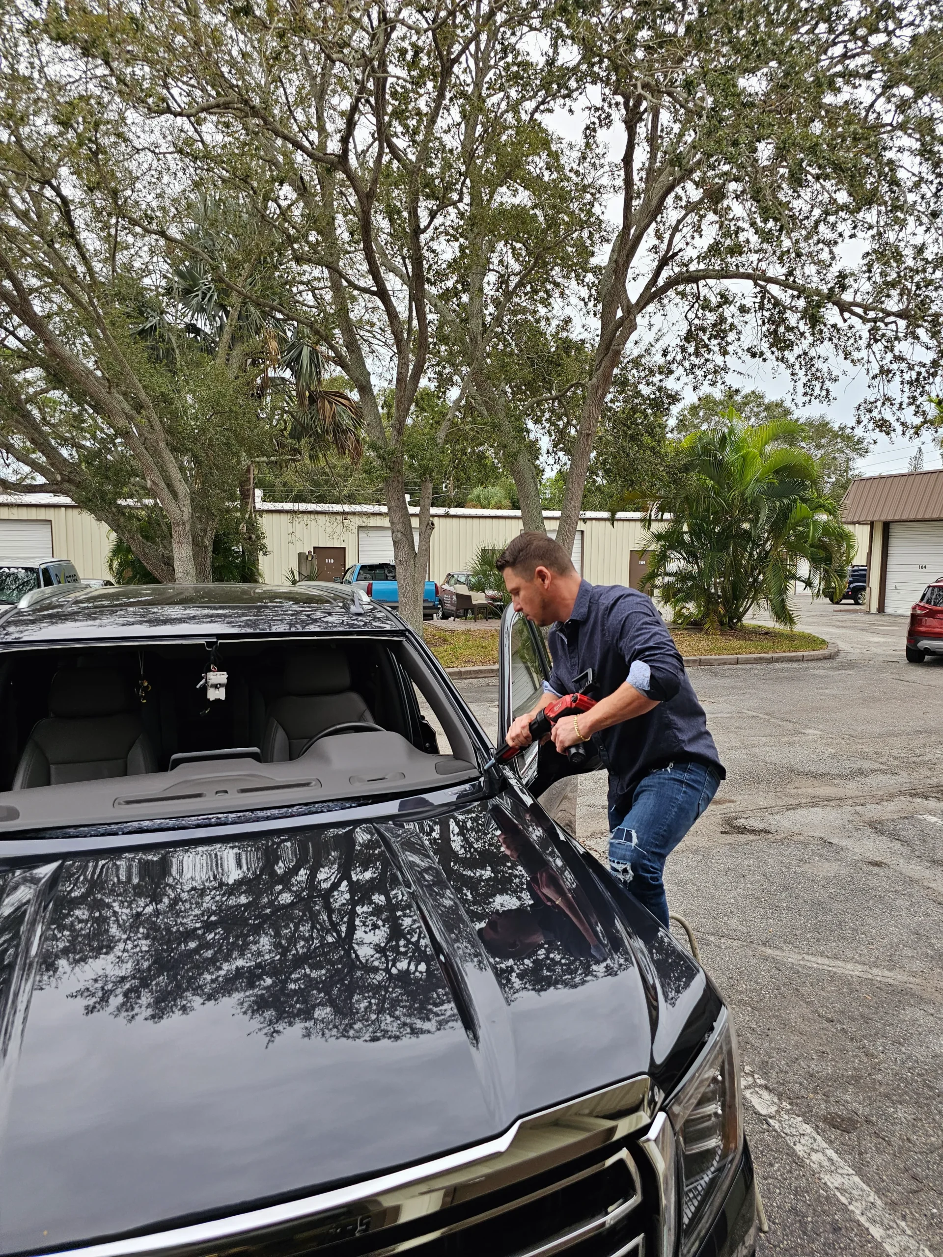 Alex Semencha owner of A Star Auto Glass installing a windshield on a black SUV in Sarasota FL