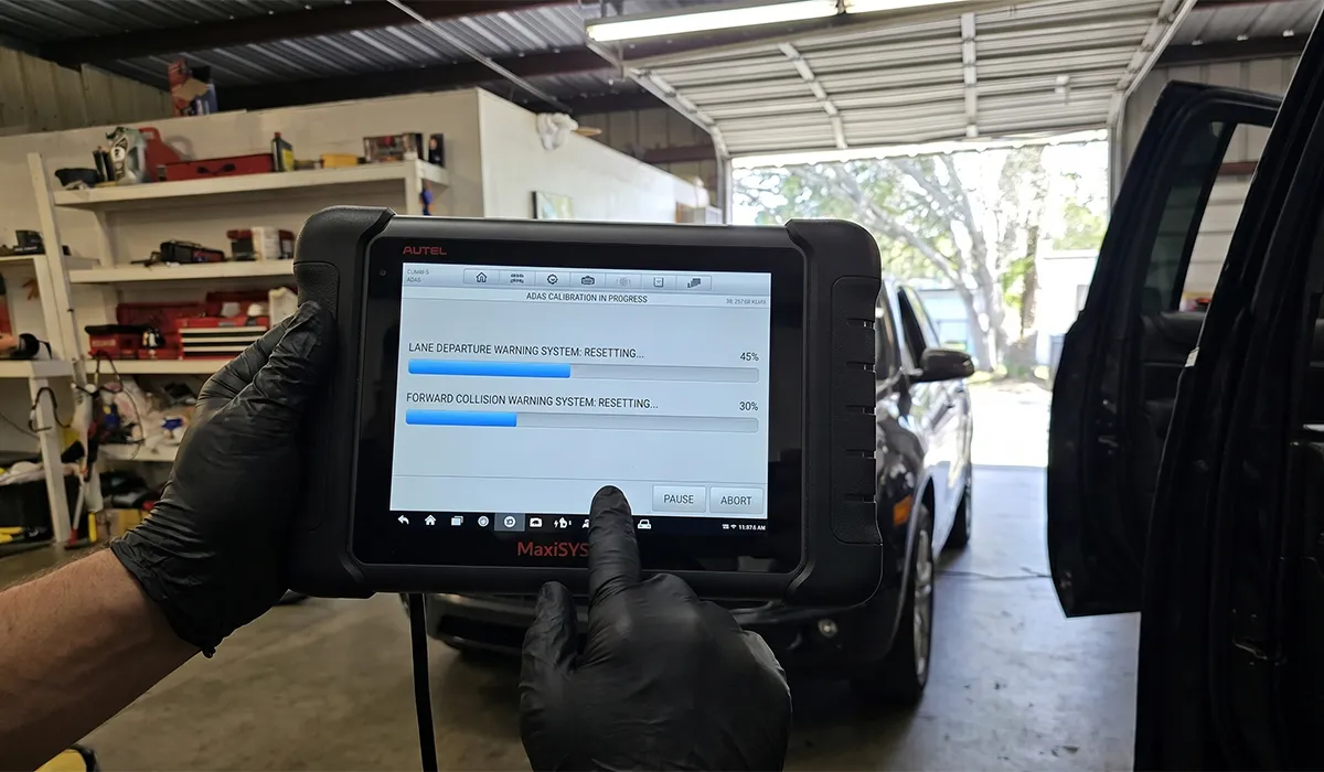 Autel MaxiSYS tablet showing ADAS calibration in progress resetting lane departure and forward collision warning systems