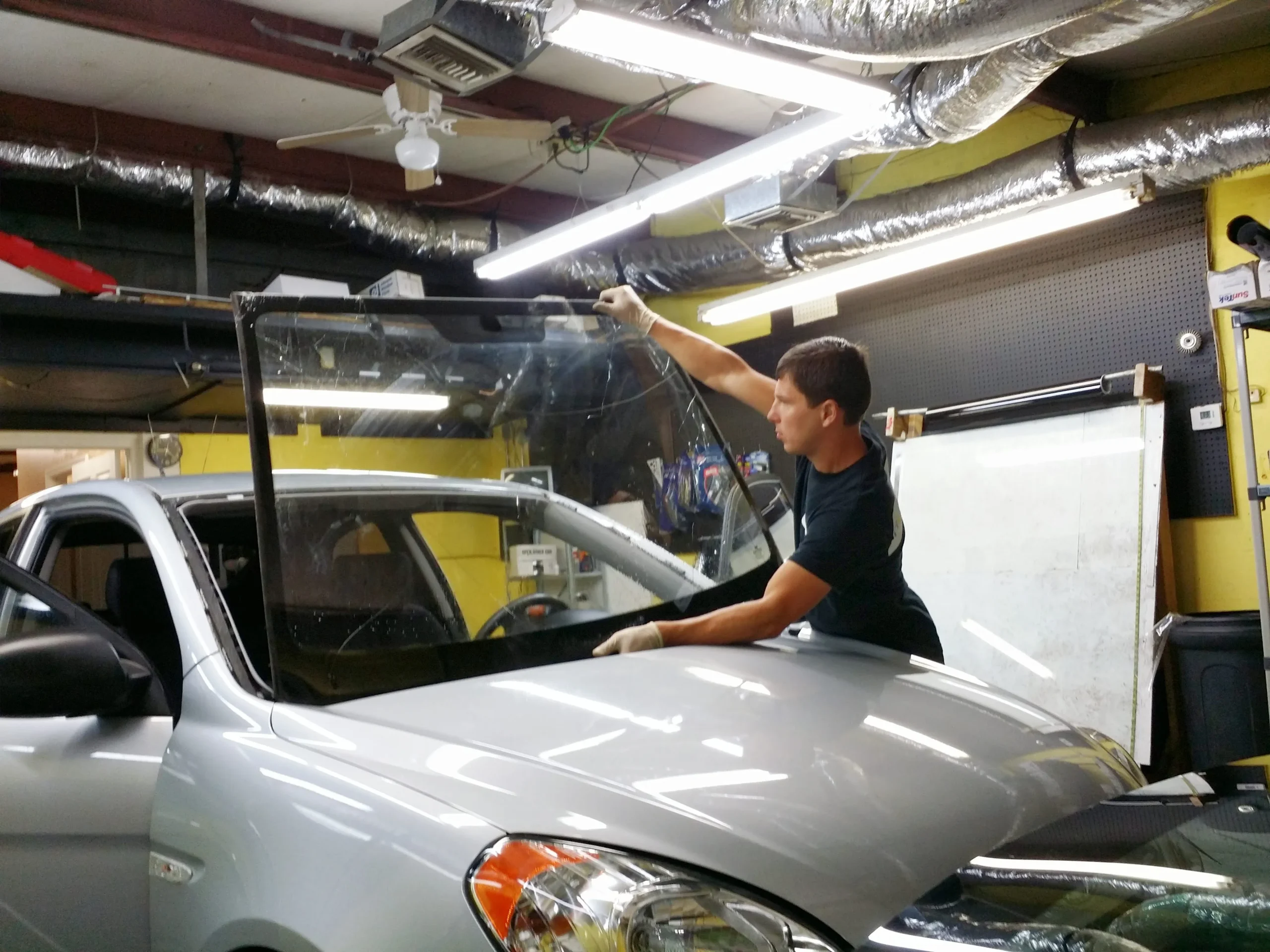 Alex installing a windshield at the A Star Auto Glass shop as part of ADAS recalibration service for Bradenton customers